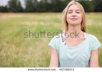 woman-with-closed-eyes-experiencing-harmony-with-nature-407188513